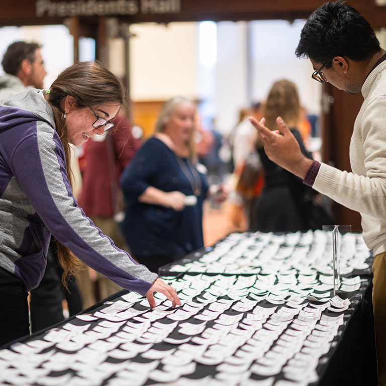 A woman stops at a table of name tags in front of an event room