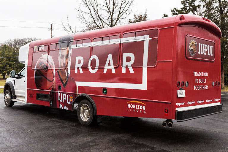 Bus wrap for the IUPUI Roar campaign with a male basketball player, the Horizon League logo, and 'Tradition is built together'