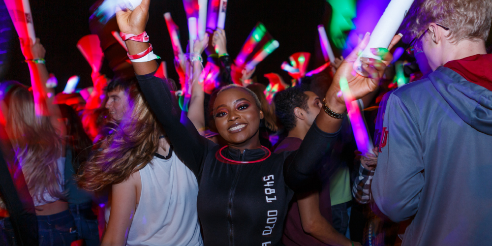 students at night holding glow sticks