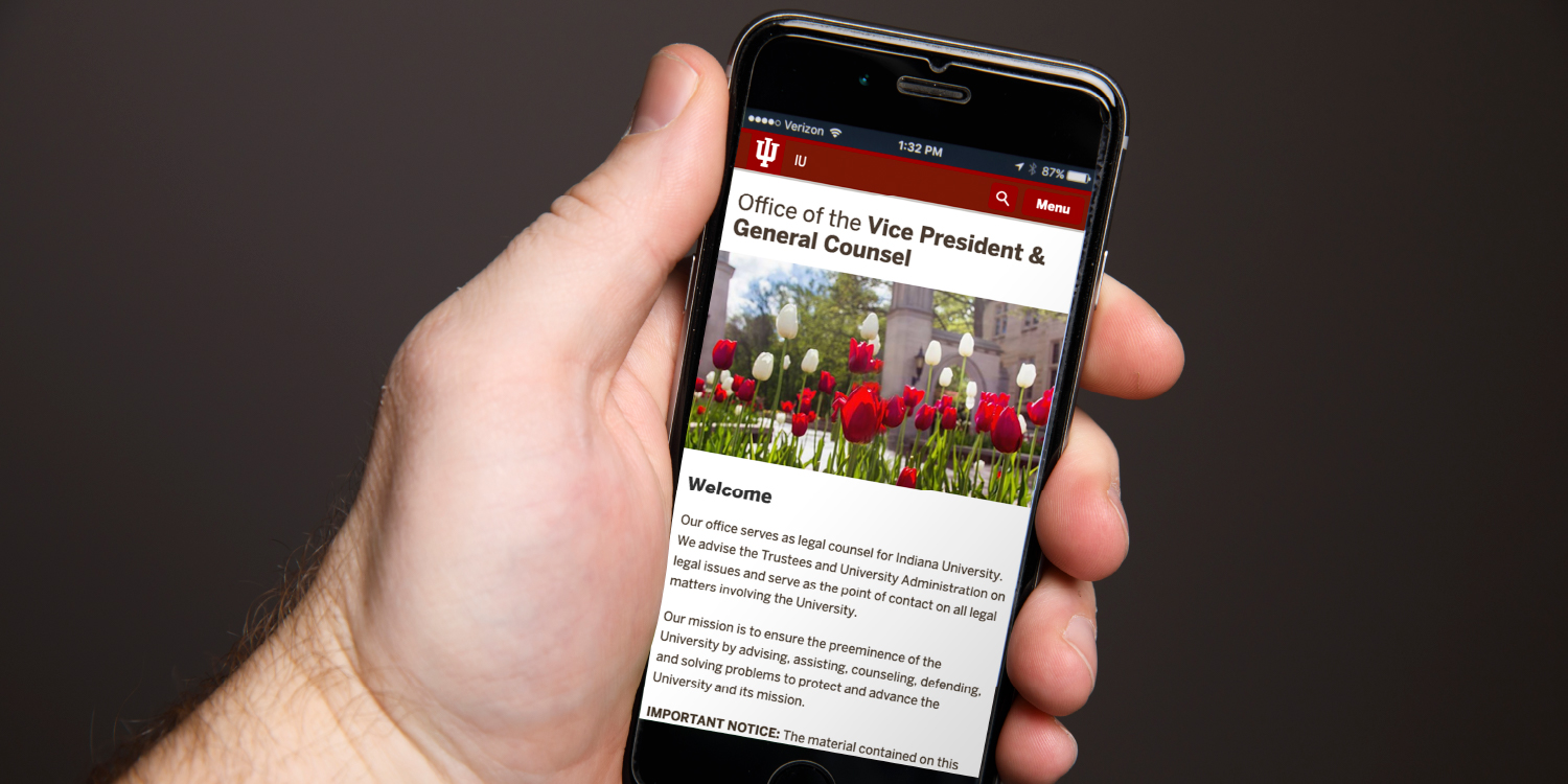 Hand holding phone showing custom webpage for Office of the Vice President & General Counsel