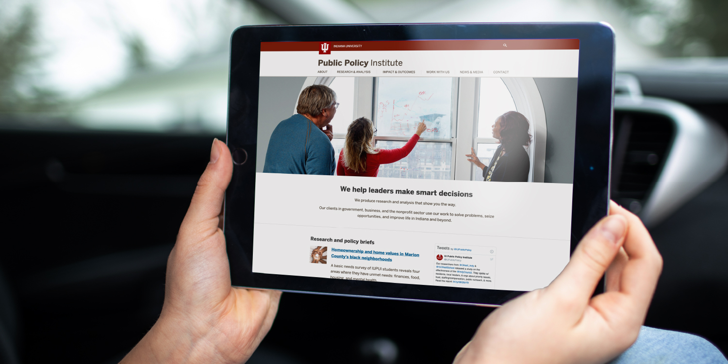 Person holding tablet showing custom webpage of the Public Policy Institute