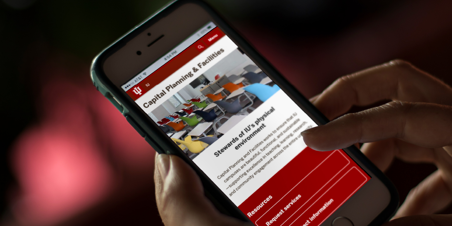Hand holding phone showing custom webpage for Capital Planning & Facilities